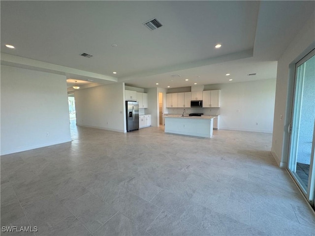 unfurnished living room featuring recessed lighting, visible vents, and baseboards