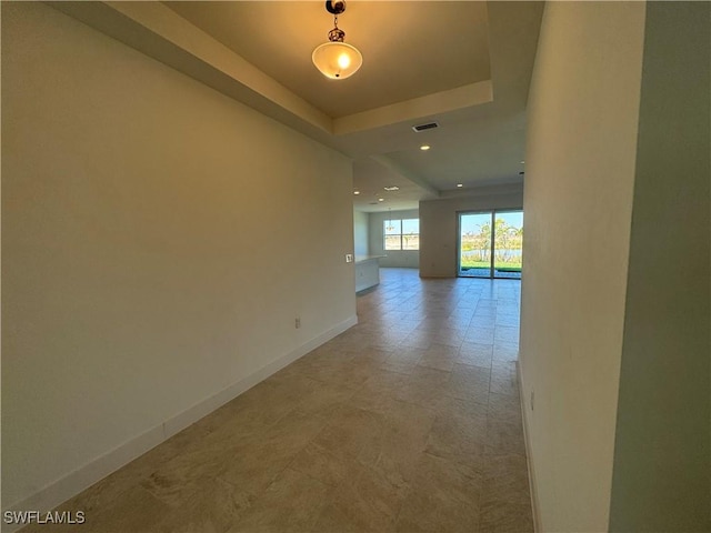 unfurnished room featuring a tray ceiling, recessed lighting, visible vents, and baseboards