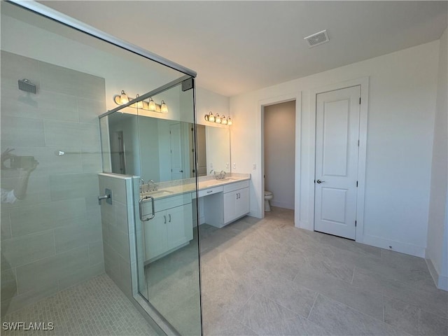 full bath with visible vents, toilet, a shower stall, vanity, and baseboards