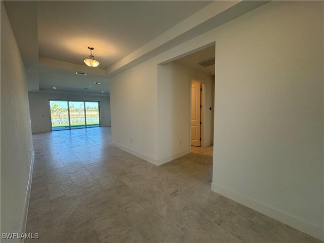 unfurnished room featuring visible vents, baseboards, and a raised ceiling