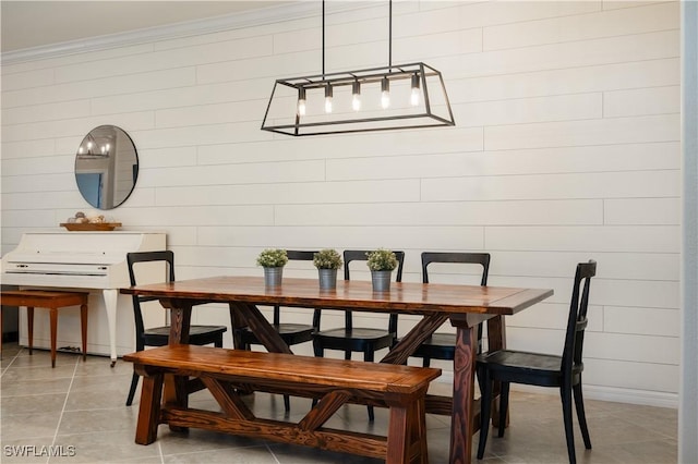 dining area featuring ornamental molding and light tile patterned floors