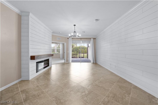 unfurnished living room with ornamental molding, an inviting chandelier, a fireplace, and light tile patterned flooring