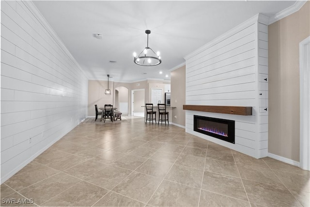 unfurnished living room featuring crown molding, an inviting chandelier, and light tile patterned floors