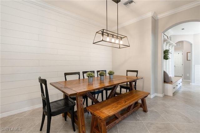 dining space with ornamental molding and light tile patterned floors