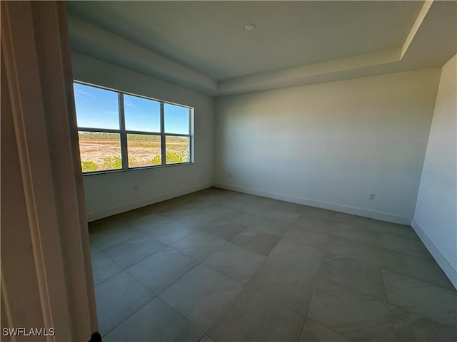 empty room featuring a raised ceiling