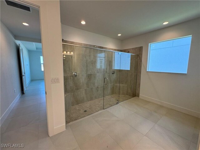 bathroom featuring tile patterned floors and a shower with shower door