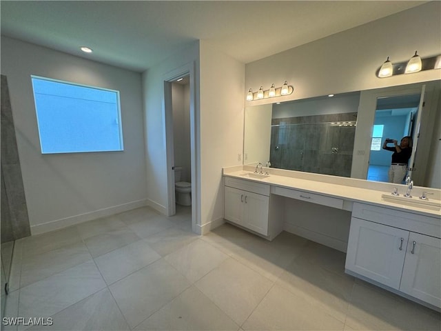 bathroom featuring tile patterned floors, vanity, toilet, and walk in shower