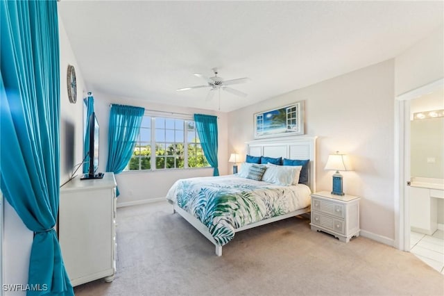 carpeted bedroom featuring ensuite bath and ceiling fan