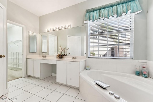 bathroom with vanity, a relaxing tiled tub, tile patterned floors, and a healthy amount of sunlight