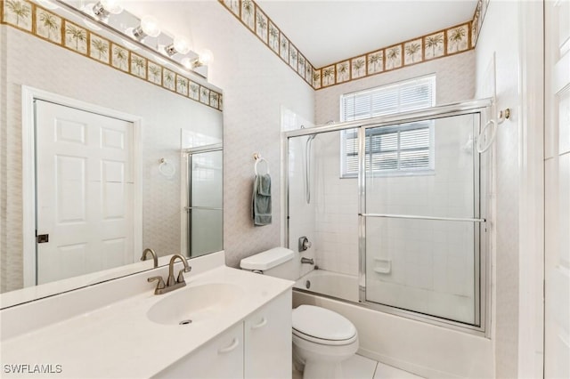 full bathroom with tile patterned flooring, vanity, bath / shower combo with glass door, and toilet