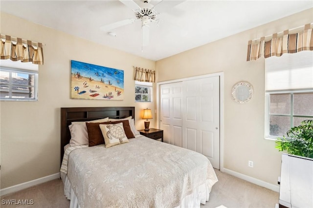 bedroom featuring light carpet, multiple windows, and ceiling fan