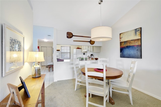 dining space with vaulted ceiling and light tile patterned flooring