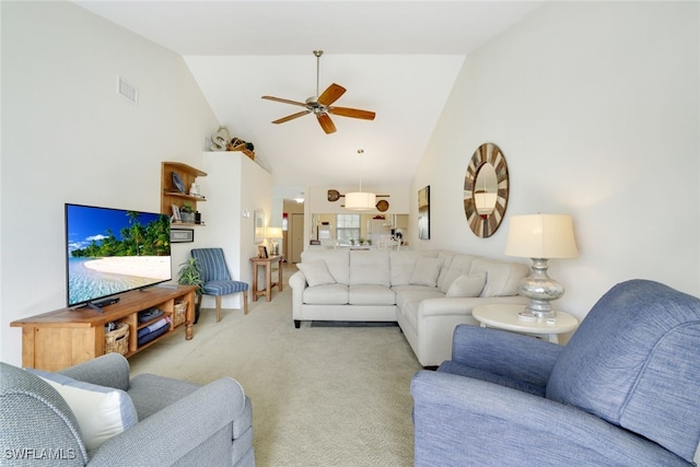 carpeted living room with ceiling fan and high vaulted ceiling