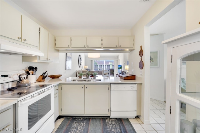 kitchen with cream cabinets, sink, light tile patterned floors, and white appliances