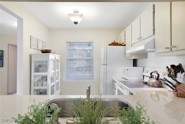 kitchen with sink, white cabinets, and white appliances