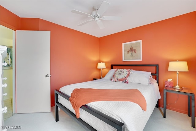 bedroom featuring ceiling fan, ensuite bathroom, and light carpet