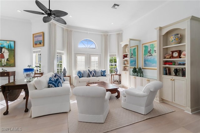 living room with built in features, light wood-type flooring, french doors, and crown molding