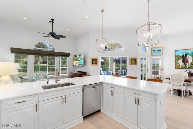 kitchen with decorative light fixtures, sink, white cabinets, and stainless steel dishwasher