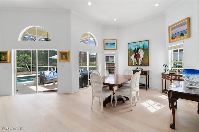 dining area with a towering ceiling and crown molding