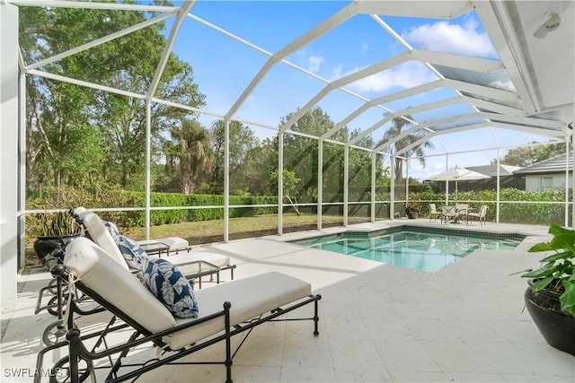 view of swimming pool with glass enclosure and a patio