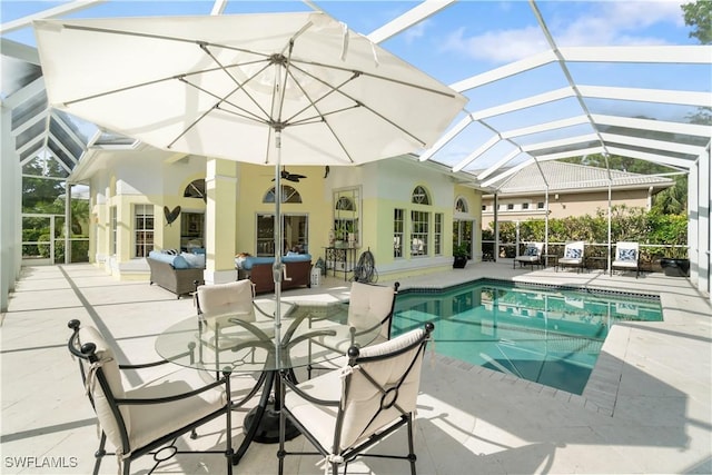 view of swimming pool with ceiling fan, a patio area, glass enclosure, and an outdoor hangout area