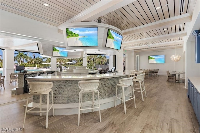 bar featuring decorative light fixtures, wooden ceiling, beamed ceiling, and light wood-type flooring