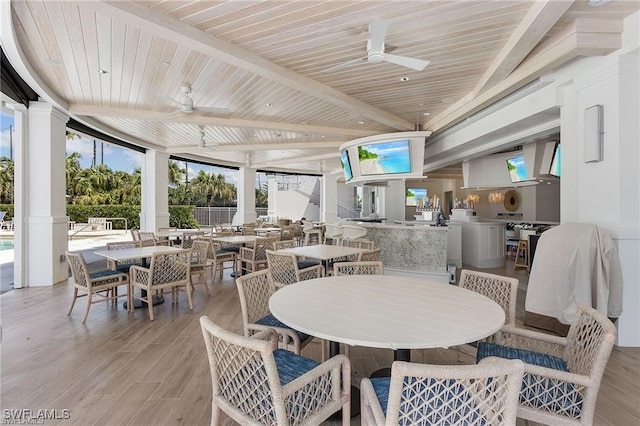 dining space featuring wooden ceiling, light wood-type flooring, floor to ceiling windows, and ceiling fan