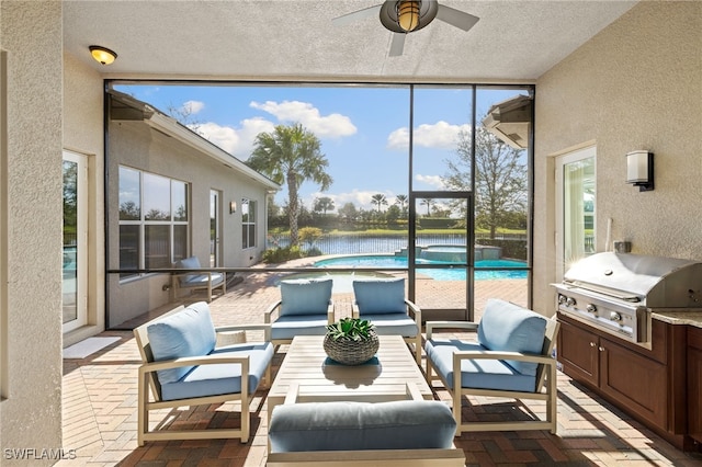 sunroom / solarium featuring ceiling fan, a healthy amount of sunlight, and a water view