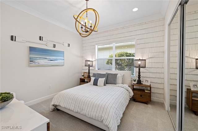 carpeted bedroom with a closet, ornamental molding, and a chandelier