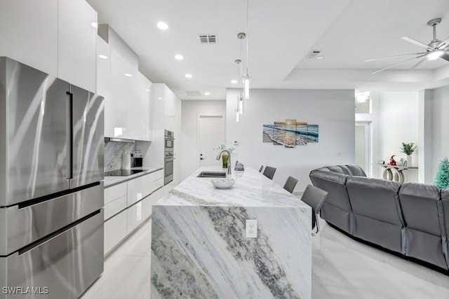 dining room featuring ceiling fan and sink