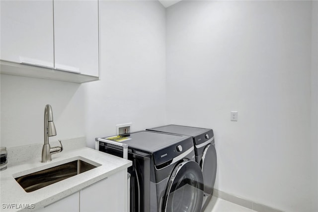 laundry area featuring separate washer and dryer, sink, and cabinets