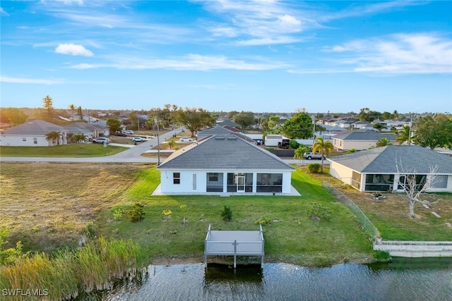 back of property featuring a water view and a sunroom