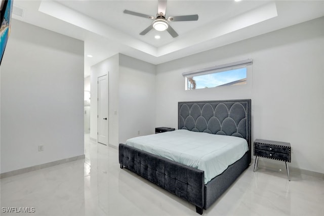 bedroom featuring a closet, a tray ceiling, and ceiling fan