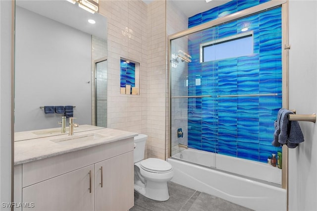 full bathroom featuring tile patterned floors, vanity, toilet, and bath / shower combo with glass door