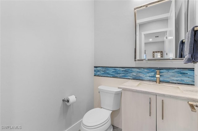 bathroom with decorative backsplash, vanity, and toilet