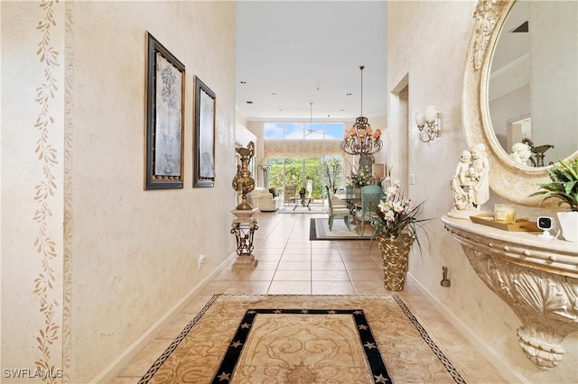 hallway with tile patterned floors and a notable chandelier