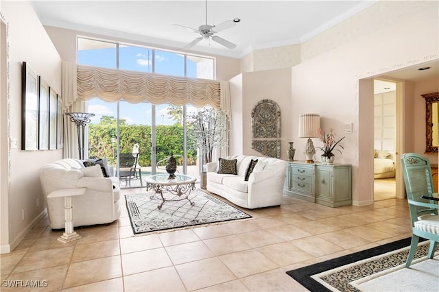 living room featuring a towering ceiling, ceiling fan, crown molding, and light tile patterned flooring