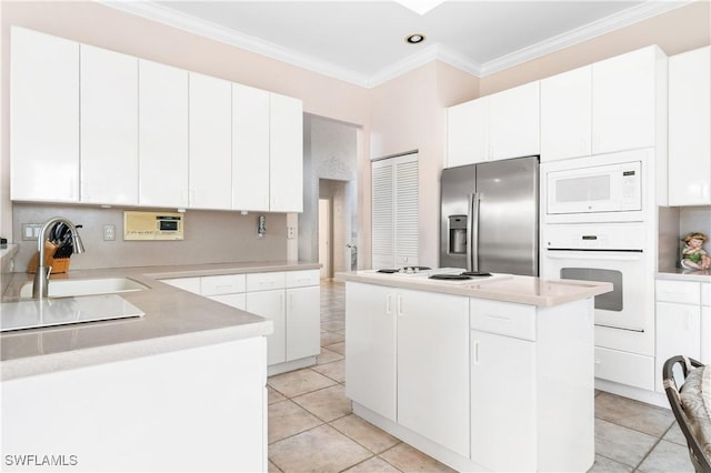 kitchen featuring white cabinetry, sink, light tile patterned floors, white appliances, and a kitchen island