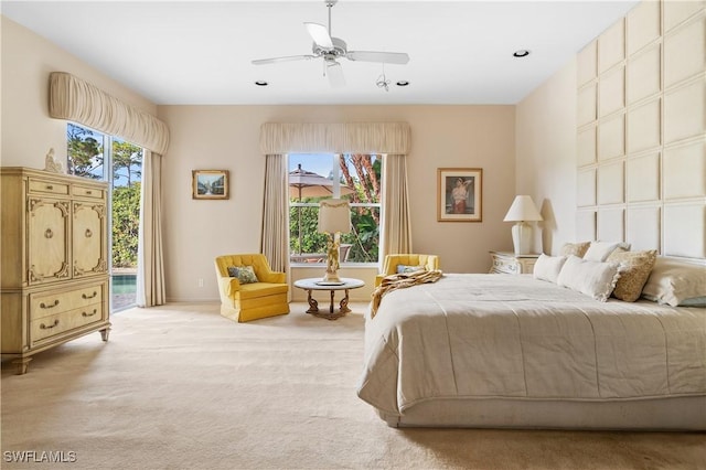 carpeted bedroom with multiple windows, access to outside, and ceiling fan