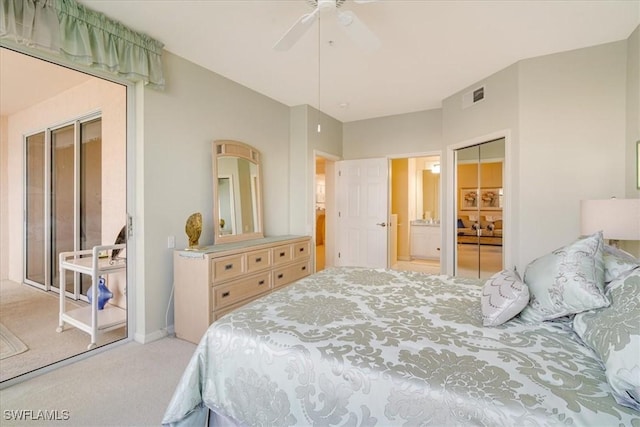 carpeted bedroom with a closet, ensuite bath, and ceiling fan