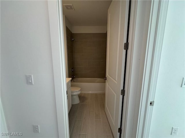 full bathroom with vanity, toilet, and tiled shower / bath combo