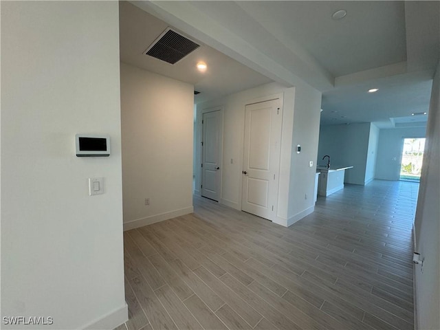 unfurnished room featuring sink and light hardwood / wood-style flooring