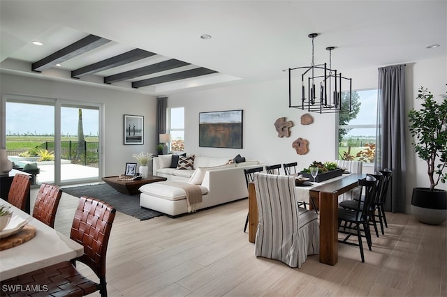 dining space featuring beamed ceiling, an inviting chandelier, and light hardwood / wood-style flooring