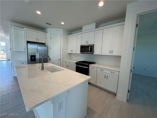 kitchen featuring visible vents, wood tiled floor, stainless steel appliances, a sink, and recessed lighting