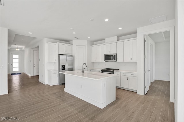 44488 Little Blue Heron Way, Punta Gorda, FL 33982 - kitchen featuring appliances with stainless steel finishes, baseboards, white cabinetry, light wood-type flooring, and light countertops