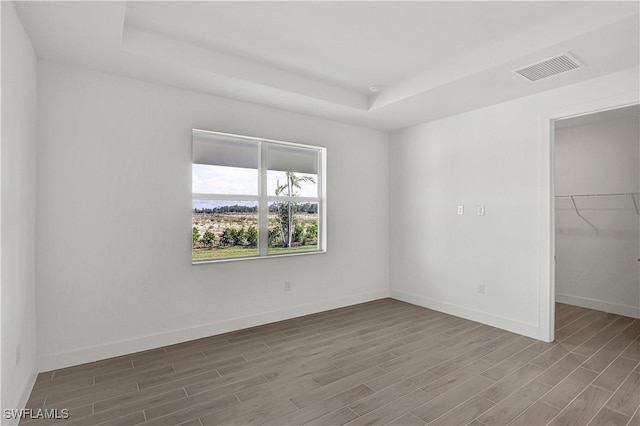 44488 Little Blue Heron Way, Punta Gorda, FL 33982 - spare room with a tray ceiling, wood finished floors, and baseboards