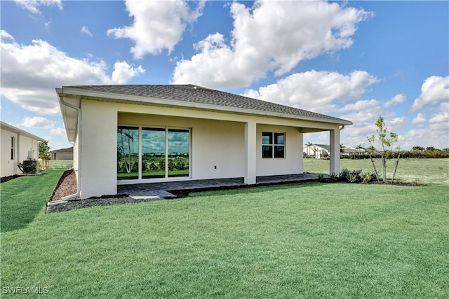 44488 Little Blue Heron Way, Punta Gorda, FL 33982 - back of house featuring stucco siding, a lawn, and cooling unit