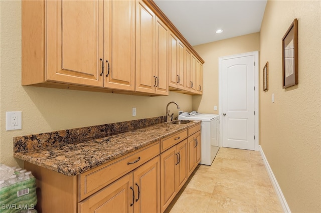 clothes washing area featuring cabinets, sink, and washing machine and dryer