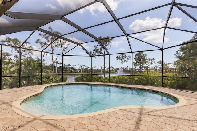 view of pool with a lanai, a patio area, and a water view