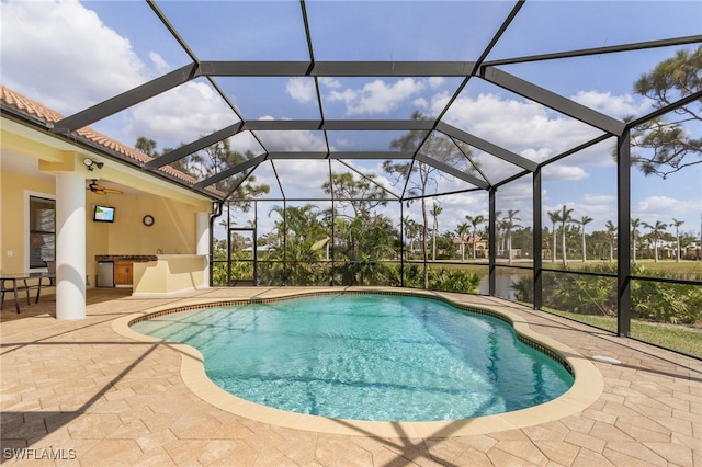 view of swimming pool with a lanai, ceiling fan, a water view, and a patio